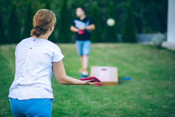 istock Couple playing bean bag toss in the backyard 2166086253