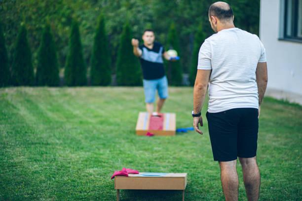 istock Two best friends playing bean bag toss in the backyard 2166086275