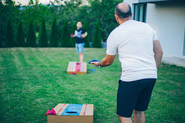 istock Two best friends playing bean bag toss in the backyard 2166086322