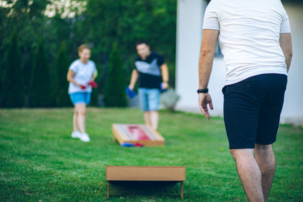 istock Best friends playing bean bag toss in the backyard 2166086359