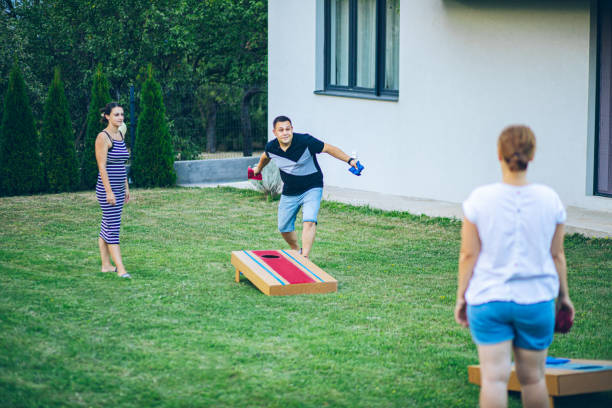 istock Best friends playing bean bag toss in the backyard 2166086364