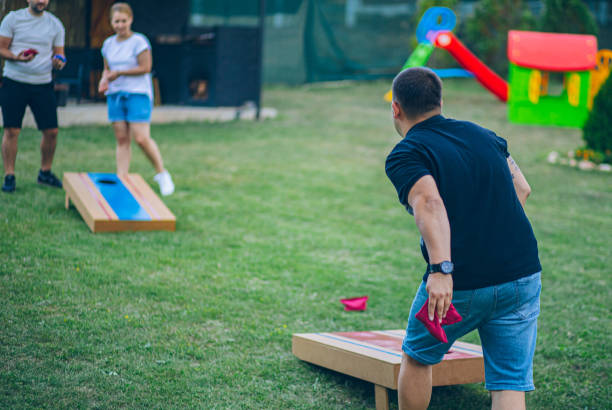 istock Best friends playing bean bag toss in the backyard 2166086375