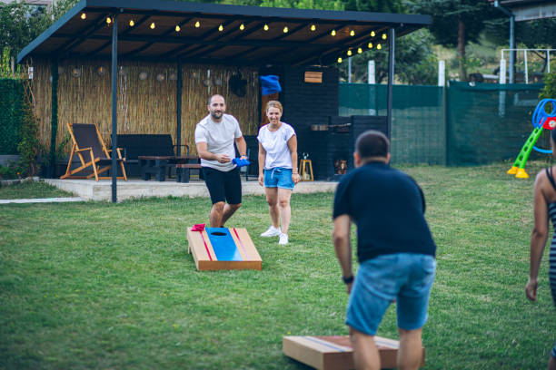 istock Best friends playing bean bag toss in the backyard 2166086396