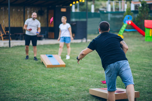 istock Best friends playing bean bag toss in the backyard 2166086409