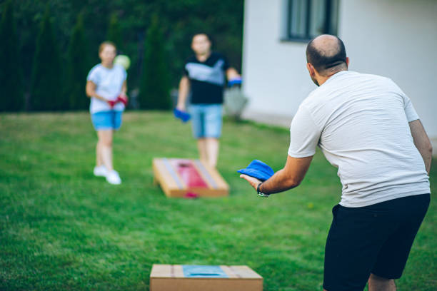 istock Best friends playing bean bag toss in the backyard 2166086423