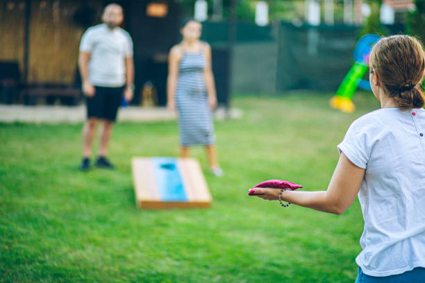 istock Best friends playing bean bag toss in the backyard 2166086434