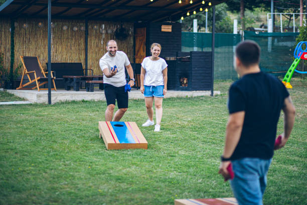 istock Best friends playing bean bag toss in the backyard 2166086979