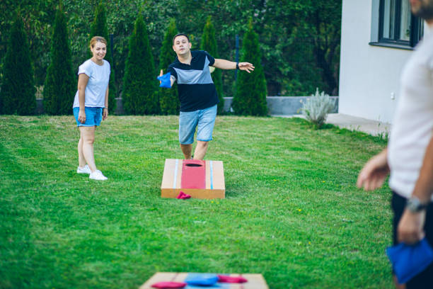 istock Best friends playing bean bag toss in the backyard 2166087000