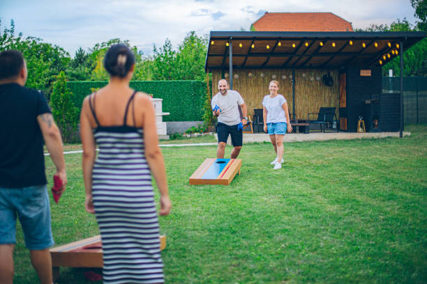 istock Best friends playing bean bag toss in the backyard 2166087120