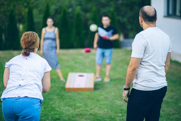 istock Best friends playing bean bag toss in the backyard 2166087138