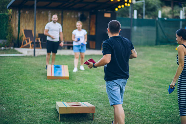 istock Two couples playing bean bag toss in the backyard 2166087198