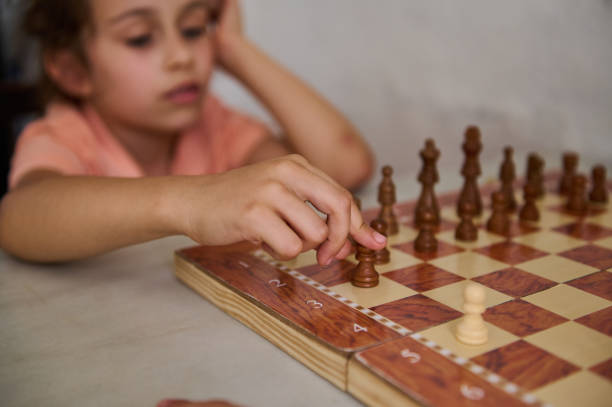 istock Young girl playing chess and making a move on the chessboard 2166094899