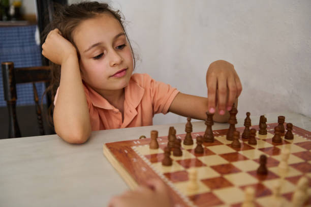 istock Young girl playing chess and making a strategic move 2166094926
