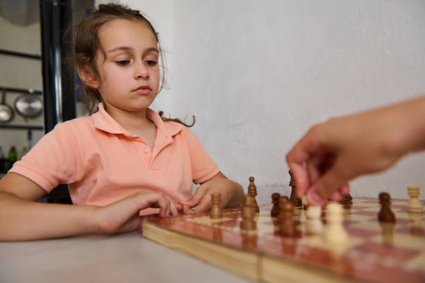 istock Young girl playing chess with concentration at home, learning strategy and critical thinking 2166094927