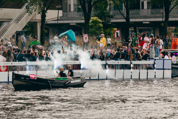 Amsterdam, Netherlands, Europe - August 3, 2024: Participants at Canal Queer and Pride Parade in the city. People are celebrating the day with rainbow symbols.