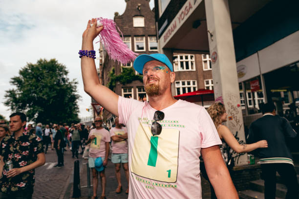 Amsterdam, Netherlands, Europe - August 3, 2024: Participants at Canal Queer and Pride Parade in the city. People are celebrating the day with rainbow symbols.