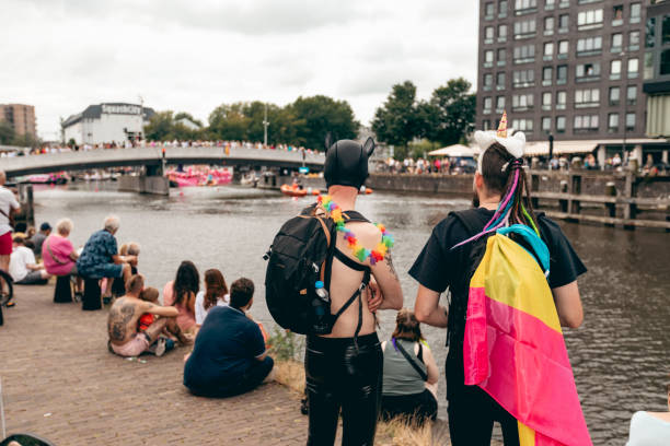 Amsterdam, Netherlands, Europe - August 3, 2024: Participants at Canal Queer and Pride Parade in the city. People are celebrating the day with rainbow symbols.