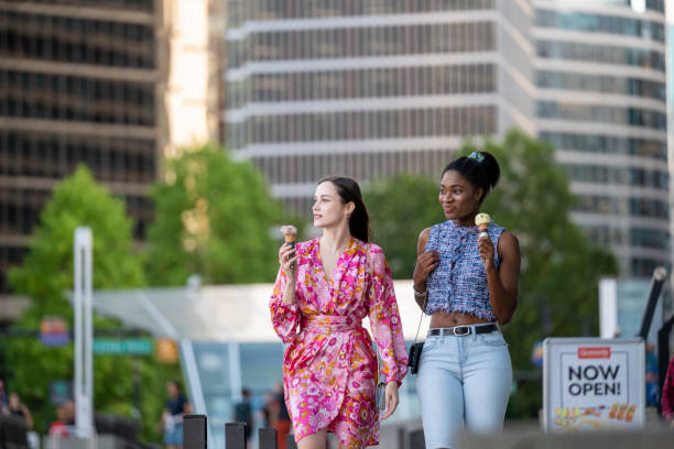 istock Young women walk on paved pathway with ice-cream cones, Vancouver 2166098356
