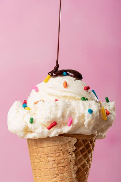 istock Vanilla Ice Cream Cone With Color Sprinkles On Top and Chocolate Drizzle 2166101591