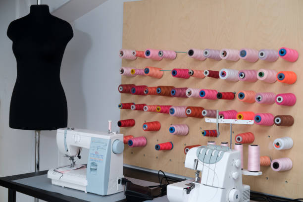 Seamstress workplace with sewing machine and colorful spools of thread