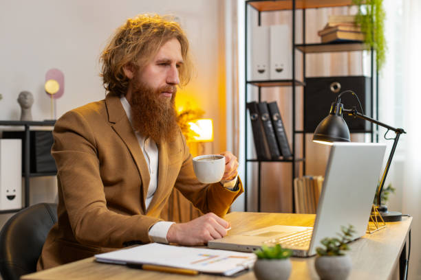 istock Businessman freelancer at home office table drinking morning coffee start working on laptop computer 2166103061