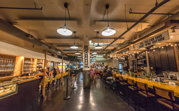 New York City, USA - July 08, 2024: View of people looking for a lunch inside a food court at the famous Chelsea Market in Midtown Manhattan, New York City. Chelsea Market is a food hall, shopping mall, office building, and television production center located in the Chelsea neighborhood of the borough of Manhattan, New York City.