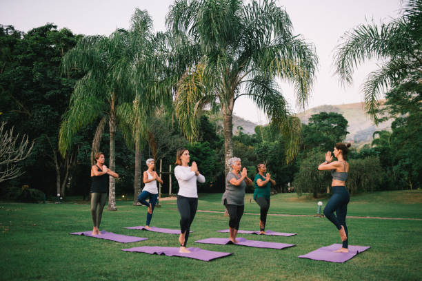 istock Group of women practicing Yoga outdoors with a instructor 2166104655