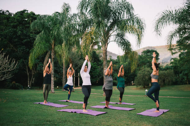 istock Group of women practicing Yoga outdoors with a instructor 2166104659