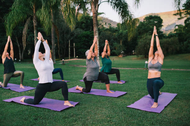 istock Group of women practicing Yoga outdoors with a instructor 2166104714