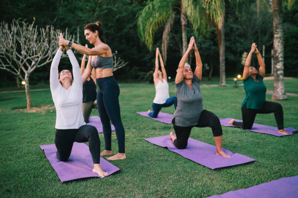 istock Group of women practicing Yoga outdoors with a instructor 2166104721