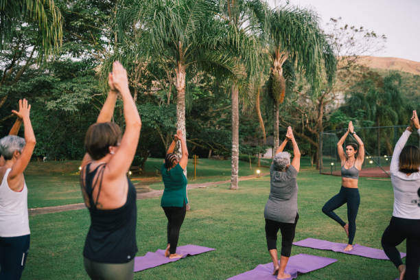 istock Group of women practicing Yoga outdoors with a instructor 2166104765