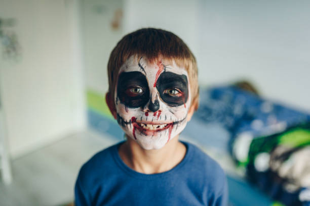 istock Boy with a painted face. Zombie Halloween costume make up. 2166110110