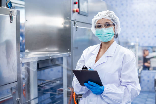 istock Female worker take note checking quality drinking water before process of filling water into plastic bottles to bring out to consumers. Water bottles on production line of factory. 2166111568