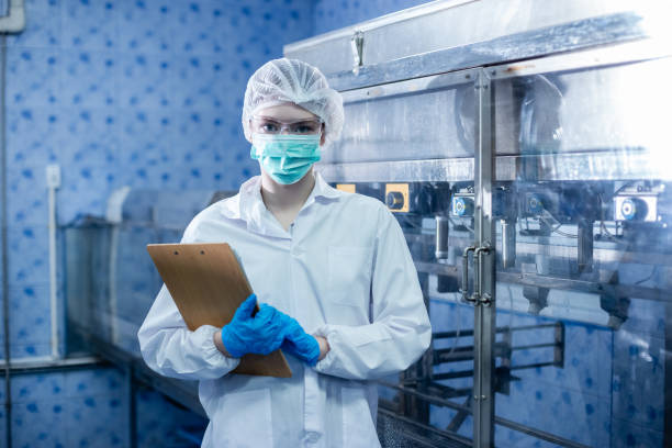 istock Female worker checking quality drinking water before process of filling water into plastic bottles to bring out to consumers. Water bottles on production line of factory. 2166111588