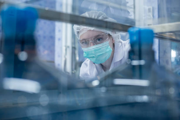 istock Female worker using tablet checking quality drinking water before process of filling water into plastic bottles to bring out to consumers. Water bottles on production line of factory. 2166111591