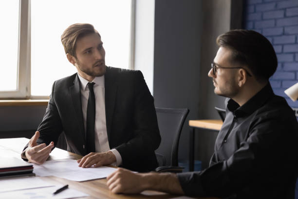 istock Two businessmen sitting at desk working on project 2166112980
