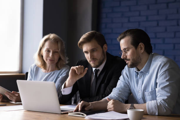 istock Three teammates working together use laptop in office 2166113648
