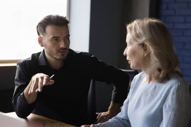 istock Two serious businesspeople work together in office 2166114189
