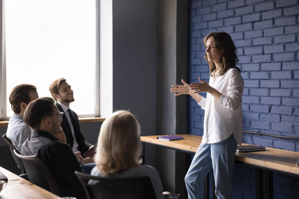 istock Young woman leader explains work tasks to company employees 2166115710