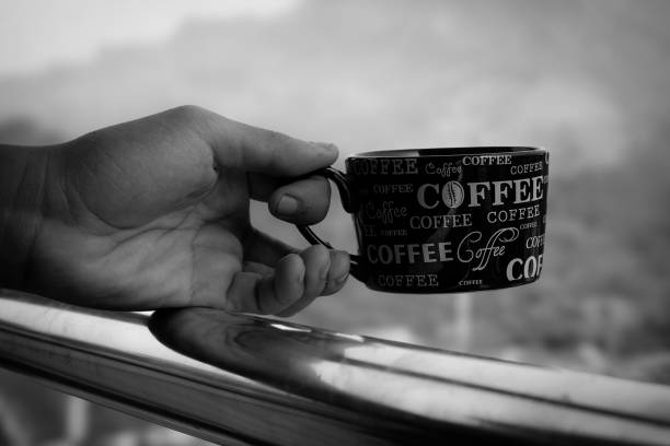 Relaxing on the balcony holding a cup of coffee