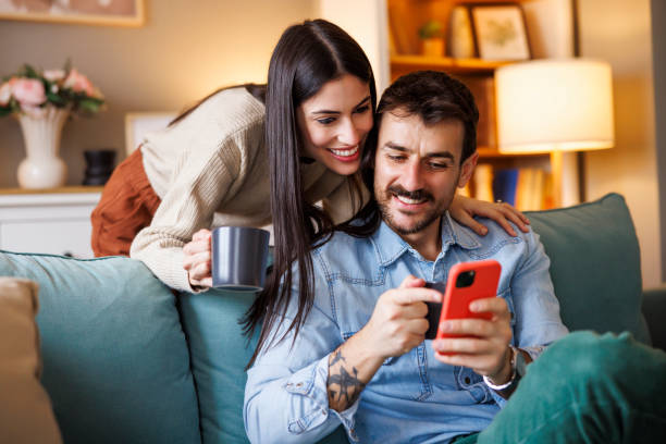 istock Couple using smart phone and drinking morning coffee at home 2166119116