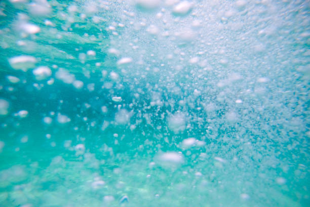 Macro close up of underwater bubbles created by a breaking wave in the ocean