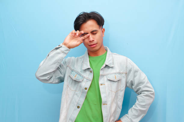 Young Asian man posing thinking about something with serious face on isolated blue background