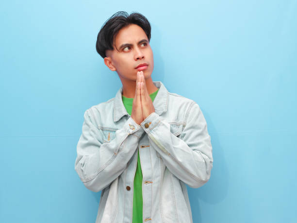 istock Young Asian man posing thinking about something with serious face on isolated blue background 2166124773