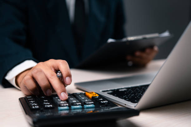 istock Business professional calculating financial data using a calculator and laptop. Suitable for financial analysis, accounting, audit, or business management content. 2166125573