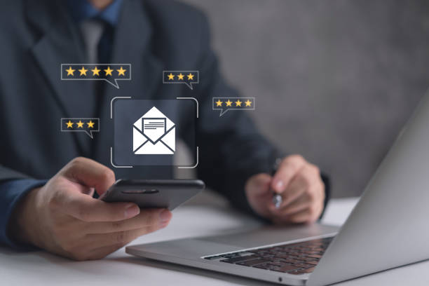 istock Hand holding a smartphone with email icon and star ratings indicating customer feedback. 2166125584
