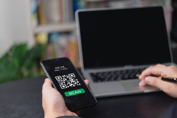 istock Hand holding smartphone with QR code on screen, ready to scan. Perfect for digital payments, e-commerce, and fintech solutions. 2166125594