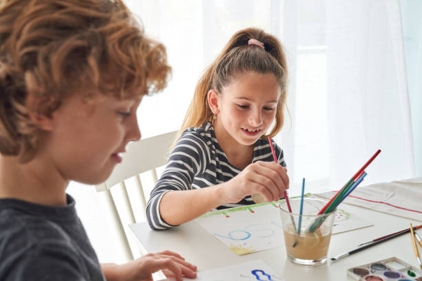 istock Cute siblings painting together at table 2166135714
