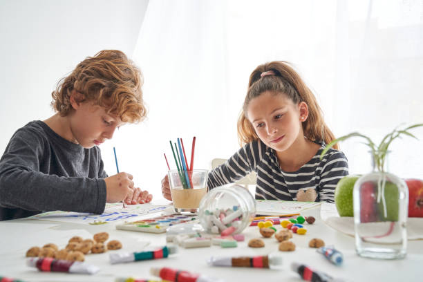 istock Concentrated siblings painting together at table 2166135744