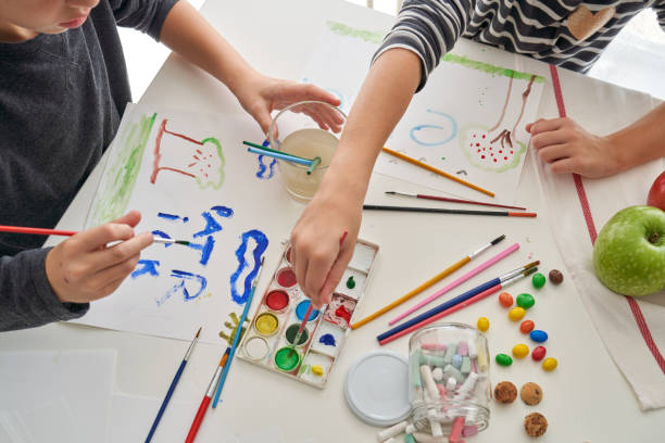 istock Unrecognizable children painting at table 2166135784